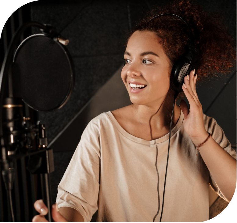 Vocal student practicing singing techniques with headphones and microphone in a recording studio.